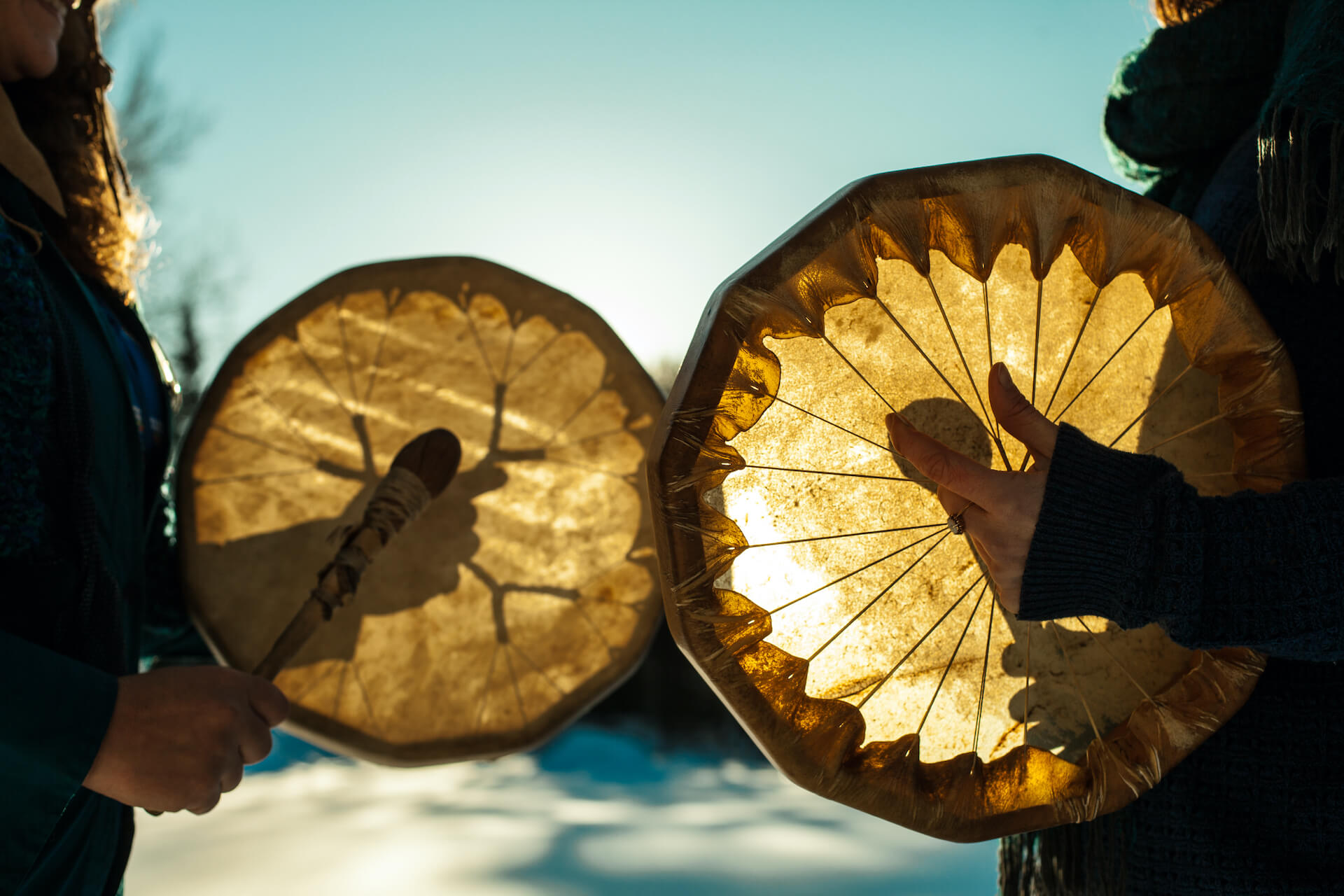 sun shining through two Indigenous drums